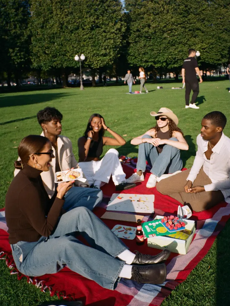 Un groupe de jeunes partage un pique-nique dans un parc
